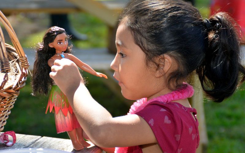 little girl playing with Moana toy
